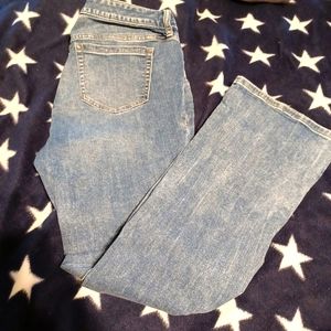 Torrid blue jeans, bootcut. Holes in each leg by knee. Has stretch